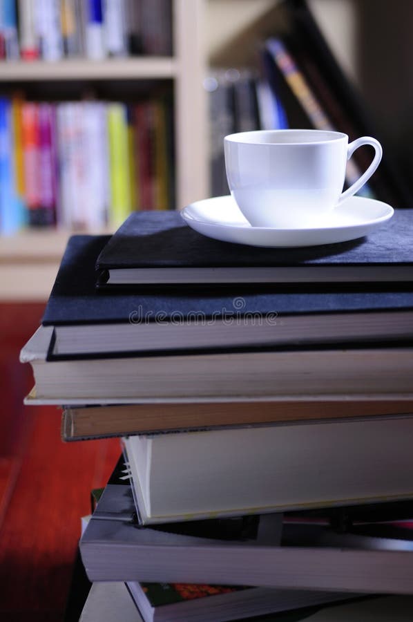 A cup of coffee and a stack of books. A cup of coffee and a stack of books.