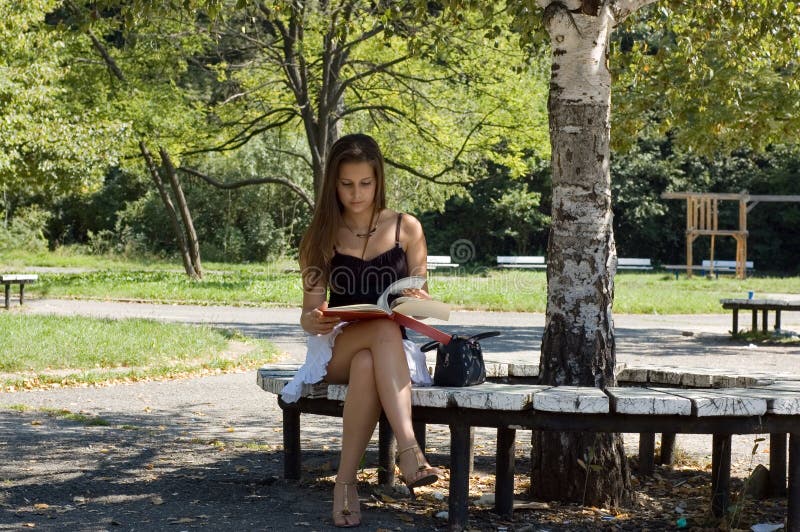 Livro de leitura da mulher no parque fotos de stock