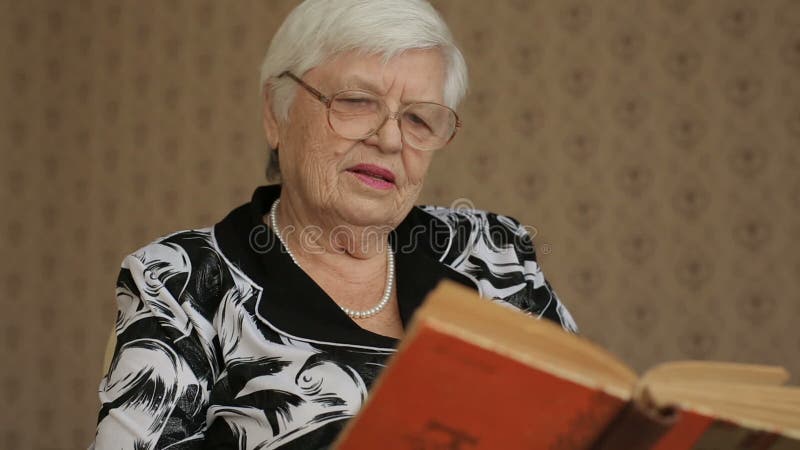 Livro de leitura sênior da mulher video estoque