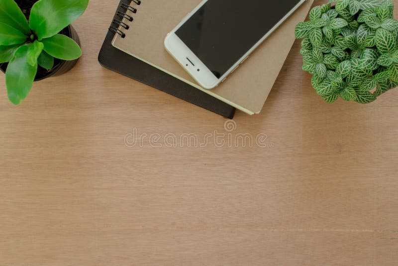 Livros, smartphone, e potenciômetro da árvore na mesa de madeira marrom rústica Espaço de trabalho do estilo de vida, vista super imagens de stock Livros, smartphone, e potenciômetro da árvore na mesa de madeira marrom rústica Espaço de trabalho do estilo de vida, vista super imagens de stock