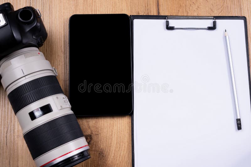 Online lessons of photo shooting. On the wooden table background are a digital tablet, a camera with lens, empty sheet and pencil for notice. Online training for photographers. . High quality photo. Online lessons of photo shooting. On the wooden table background are a digital tablet, a camera with lens, empty sheet and pencil for notice. Online training for photographers. . High quality photo