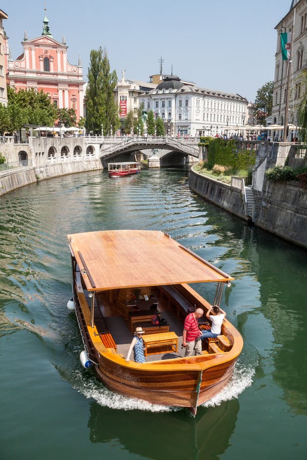 Ljubljana, Eslovenia Río de Ljubljanica Edificio blanco y barco turístico fotos de archivo libres de regalías Ljubljana, Eslovenia Río de Ljubljanica Edificio blanco y barco turístico fotos de archivo libres de regalías