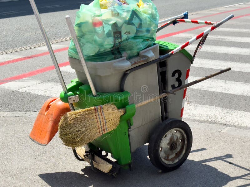 Ljubljana, Slovenia - June 03, 2025: Street cleaning cart with green trash bin, broom, and plastic bags, showcasing urban royalty free stock photo