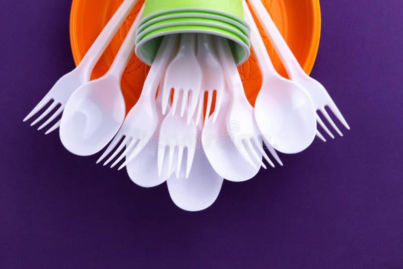 Ljus orange och grön uppsättning av disponibel plast- bordsservis på purpurfärgad bakgrund Ekologiproblem Inget plast- begrepp royaltyfri bild Ljus orange och grön uppsättning av disponibel plast- bordsservis på purpurfärgad bakgrund Ekologiproblem Inget plast- begrepp royaltyfri bild