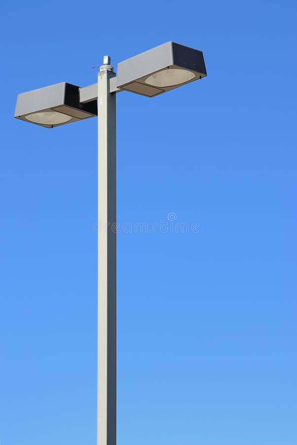 A light pole isolated against a blue sky. A light pole isolated against a blue sky