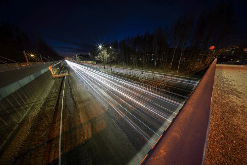Ljusa slingor från bilar på Kehä 1 på Helsingfors fångade på natten med den mycket breda vinkellinsen och lång exponerin arkivfoton Ljusa slingor från bilar på Kehä 1 på Helsingfors fångade på natten med den mycket breda vinkellinsen och lång exponerin arkivfoton