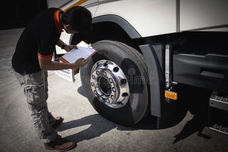 LKW-Fahrer überprüfen die Sicherheitsprüfliste. Reifen für Sattelkraftfahrzeuge stockfotografie