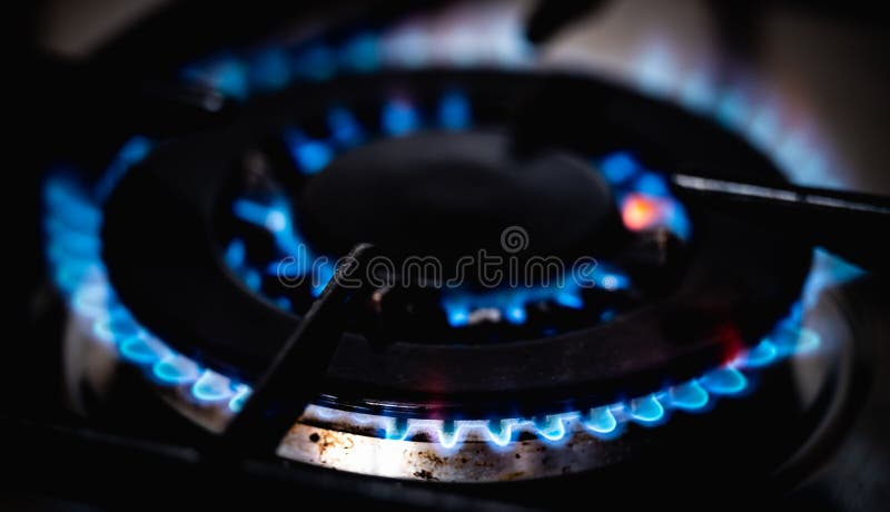 Quemador con llama amarilla azul en la cocina de gas para cocinar
