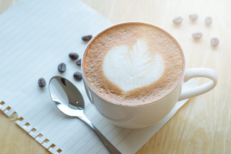 LLatte konstkaffe och grillade kaffebönor på morgontid med fotografering för bildbyråer LLatte konstkaffe och grillade kaffebönor på morgontid med fotografering för bildbyråer