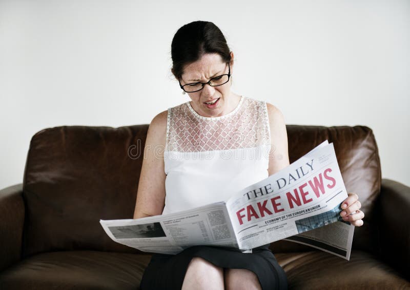 Lle notizie di falsificazione della lettura della donna immagini stock libere da diritti Lle notizie di falsificazione della lettura della donna immagini stock libere da diritti