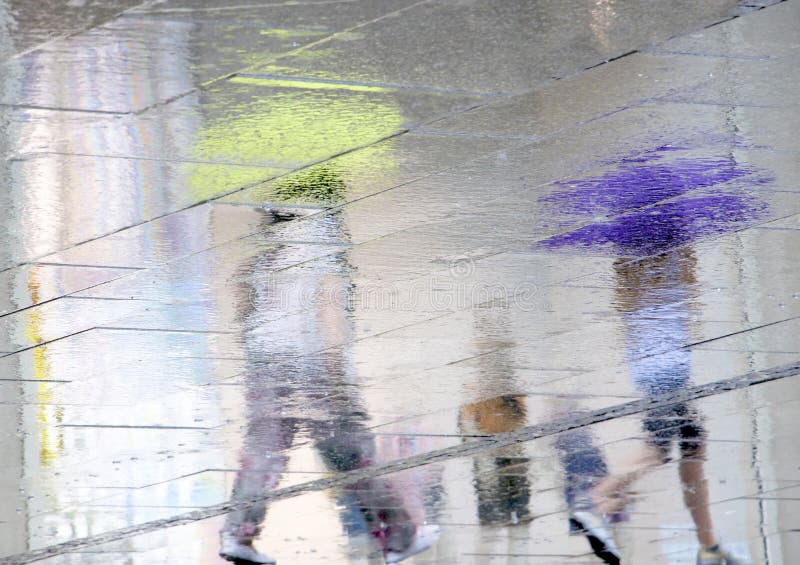 Lle siluette confuse di riflessione di due genti che camminano su un piovoso fotografia stock libera da diritti Lle siluette confuse di riflessione di due genti che camminano su un piovoso fotografia stock libera da diritti