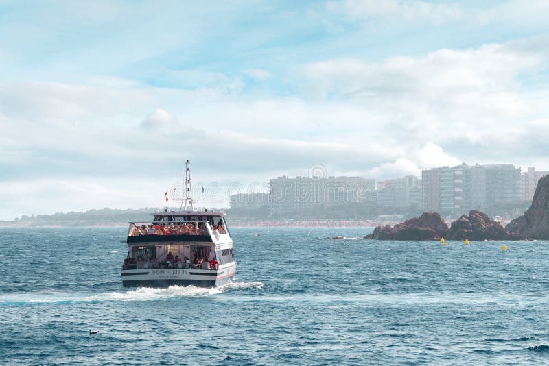 LLORET DE MAR,SPAIN - AUGUST 8, 2019: Passenger pleasure boat with tourists on a sea walk off the coast of Spain. stock images LLORET DE MAR,SPAIN - AUGUST 8, 2019: Passenger pleasure boat with tourists on a sea walk off the coast of Spain. stock images