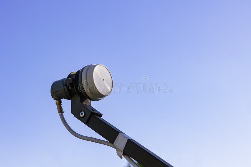 LNB on the feedhorn isolated on blue sky background. Satallite communication background photo.