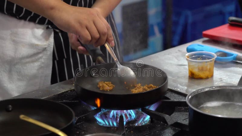 Lo chef cucina il cibo cinese tradizionale fritto