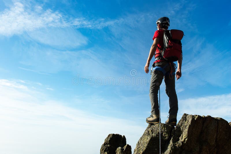 Lo scalatore arriva sulla sommità di un picco di montagna Concetti: victo immagine stock Lo scalatore arriva sulla sommità di un picco di montagna Concetti: victo immagine stock