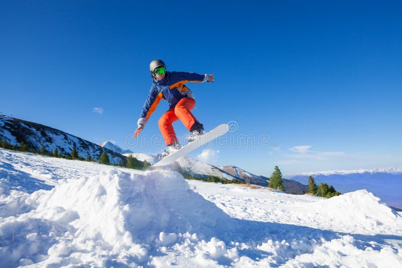 Lo Snowboarder che salta su dalla collina nell'inverno fotografia stock Lo Snowboarder che salta su dalla collina nell'inverno fotografia stock