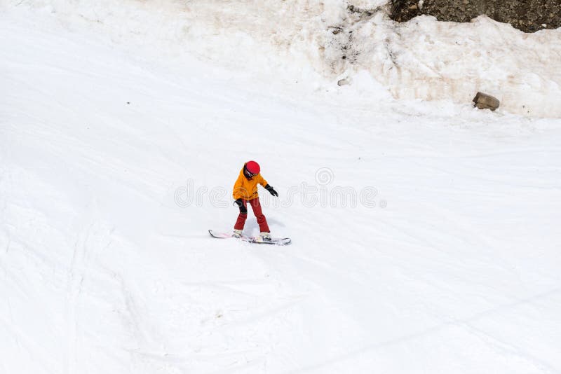 Lo Snowboarder guida giù un pendio della neve fotografie stock