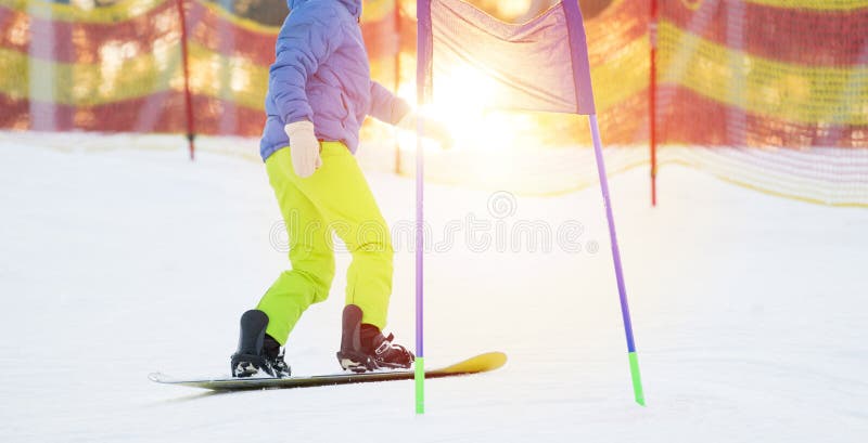 Una snowboarder scende la montagna con la sua tavola da snowboard fotografia stock