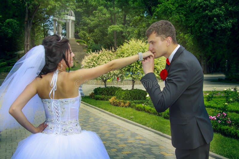 Lo sposo bacia la sua mano del ` s della sposa immagine stock Lo sposo bacia la sua mano del ` s della sposa immagine stock
