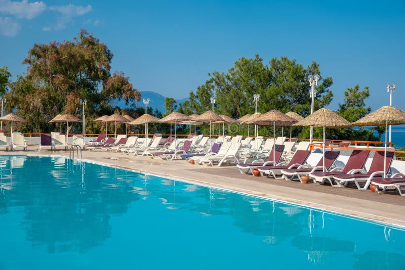 Lo stagno con i lettini e gli ombrelli è vicino al mare Concetto di turismo fotografie stock libere da diritti Lo stagno con i lettini e gli ombrelli è vicino al mare Concetto di turismo fotografie stock libere da diritti