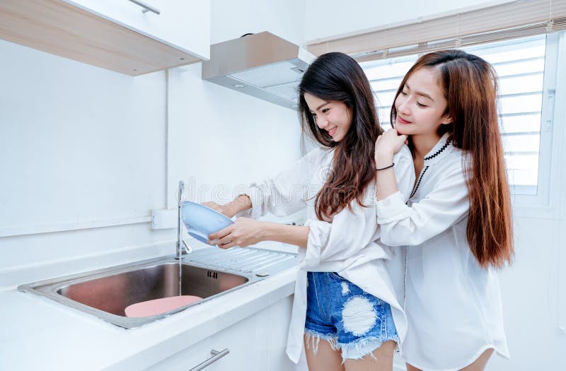 Lo stesso asiatico lesbico asiatico delle donne delle coppie del sesso che fa lavoro domestico immagine stock Lo stesso asiatico lesbico asiatico delle donne delle coppie del sesso che fa lavoro domestico immagine stock