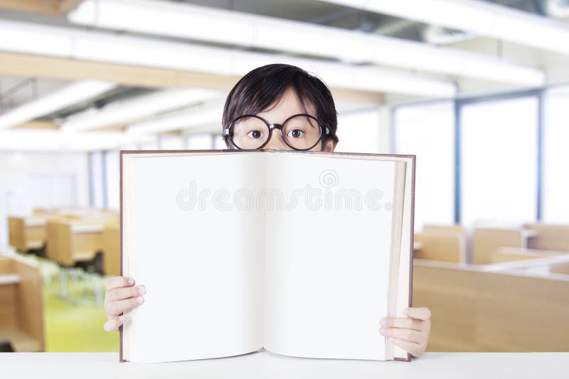 Lo studente di asilo mostra il libro vuoto nella classe immagini stock Lo studente di asilo mostra il libro vuoto nella classe immagini stock