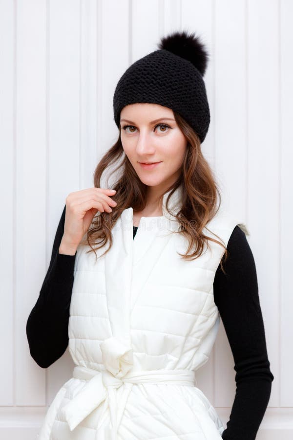 Lo Swag castana della ragazza di stile dei pantaloni a vita bassa che porta il beanie nero di modo ha tricottato il cappello con fotografia stock Lo Swag castana della ragazza di stile dei pantaloni a vita bassa che porta il beanie nero di modo ha tricottato il cappello con fotografia stock