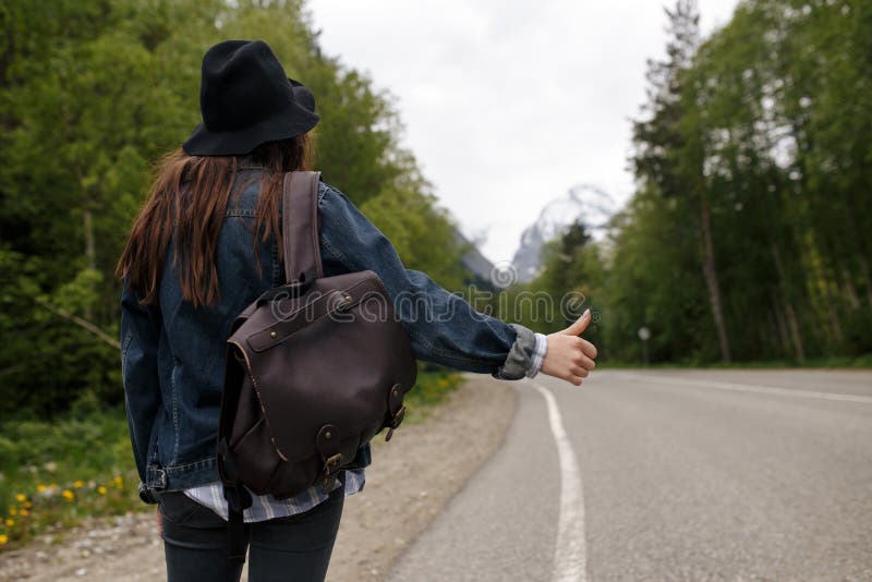 Lo zaino felice della ragazza nei precedenti della foresta e della strada, si rilassa il tempo sul viaggio di concetto di festa, immagini stock Lo zaino felice della ragazza nei precedenti della foresta e della strada, si rilassa il tempo sul viaggio di concetto di festa, immagini stock