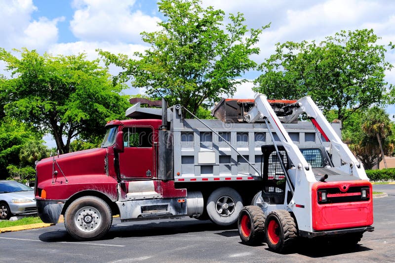 Loader loading truck in parking lot