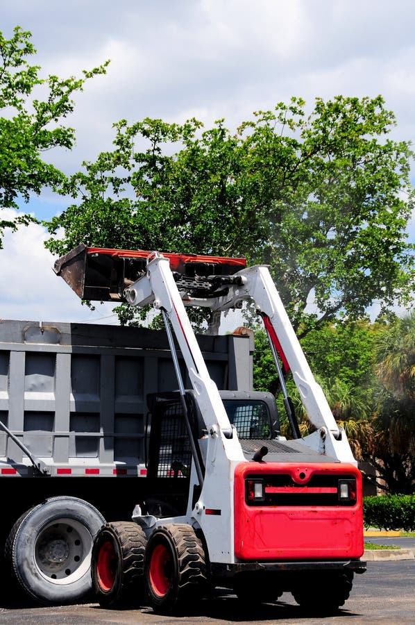 Loader loading truck in South Florida parking lot