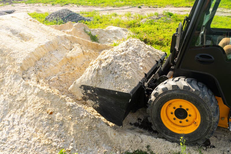 The Loader Took the Sand into the Bucket for Construction Work Stock