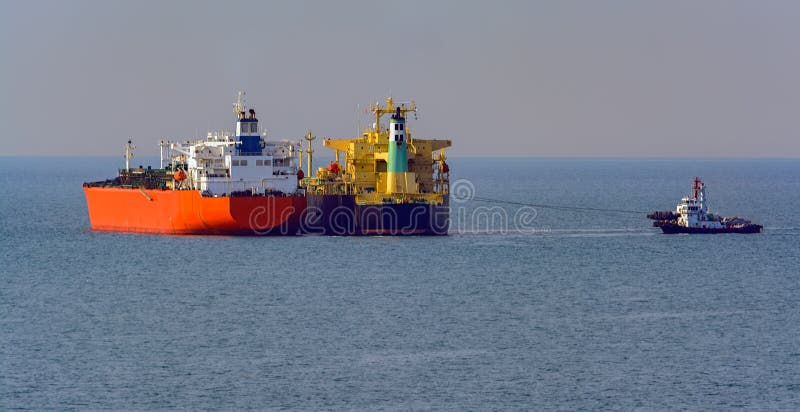 Loading anchored oil supertanker via a ship-to-ship oil transfer stock photography