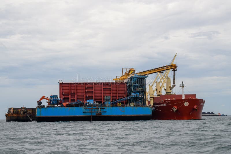 Loading Coal from Cargo Barges Onto a Bulk Vessel Using Ship Cranes