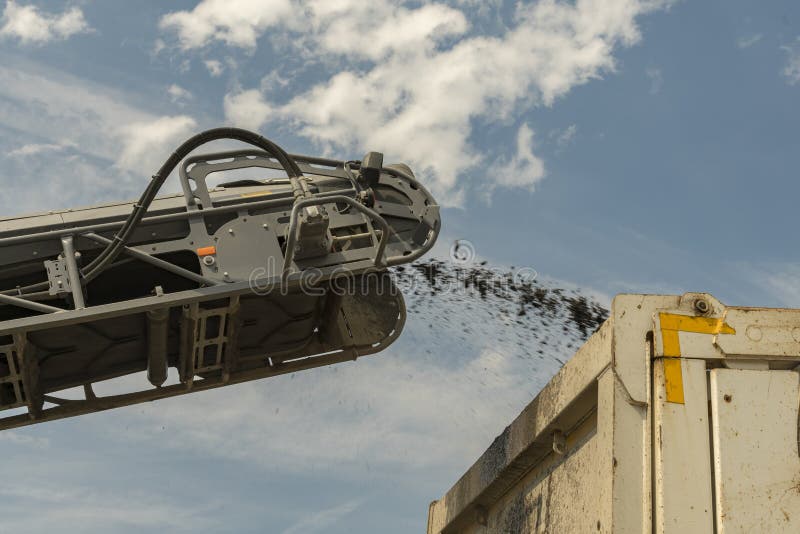 Loading Road Debris in the Car. a Heavy Tractor Removes the Old Asphalt