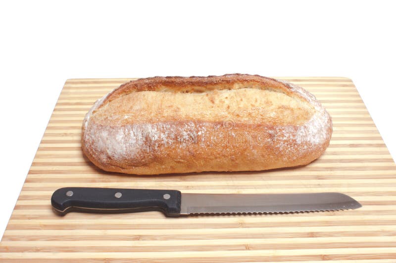 Loaf of bread and knife on board