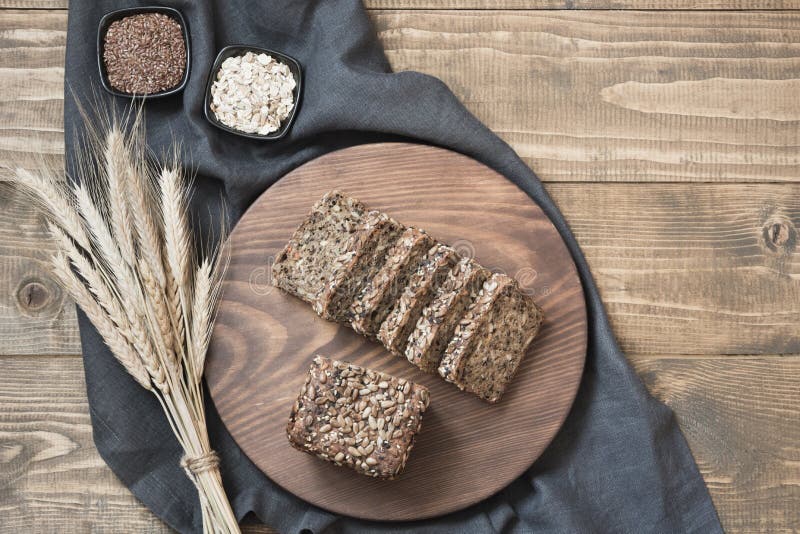 A loaf of fresh rustic whole rye bread on wooden table. Healphy food background. Top view. Copy space. Fitness