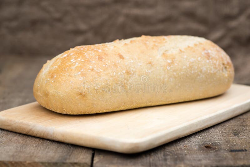 Sourdough loaf of bread in rustic kitched setting. Sourdough loaf of bread in rustic kitched setting