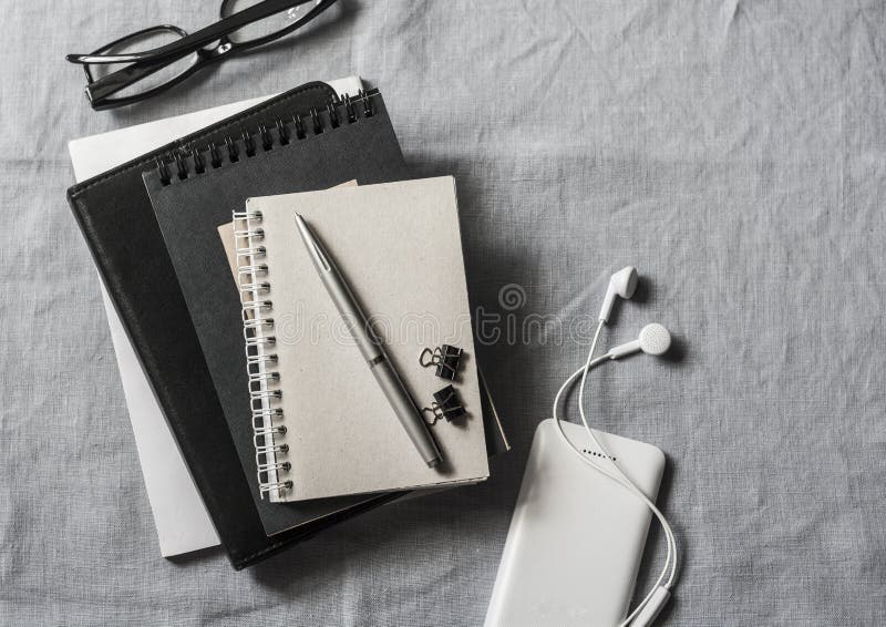 Local de trabalho com negócio, acessórios da educação Tabuleta, telefone, fones de ouvido, bloco de notas, pena, vidros no fundo imagens de stock Local de trabalho com negócio, acessórios da educação Tabuleta, telefone, fones de ouvido, bloco de notas, pena, vidros no fundo imagens de stock