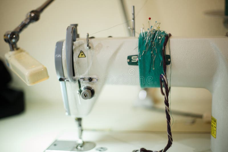 Local de trabalho da costureira Linhas das tesouras da máquina de costura e outras ferramentas Costurando a indústria foto de stock Local de trabalho da costureira Linhas das tesouras da máquina de costura e outras ferramentas Costurando a indústria foto de stock
