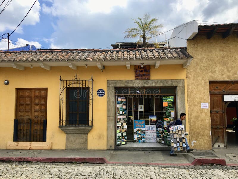 Antigua Guatemala, Guatemala - May 19th, 2018: A local guatemalan man selling guided tours and souvenirs from a local hostel to sites around Anitigua, for any interested tourists walking by.