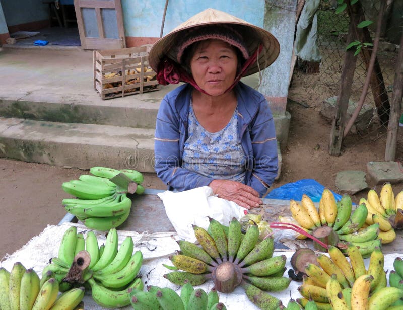 A local woman in the traditional Vietnamese selling bananas in the market stock images A local woman in the traditional Vietnamese selling bananas in the market stock images