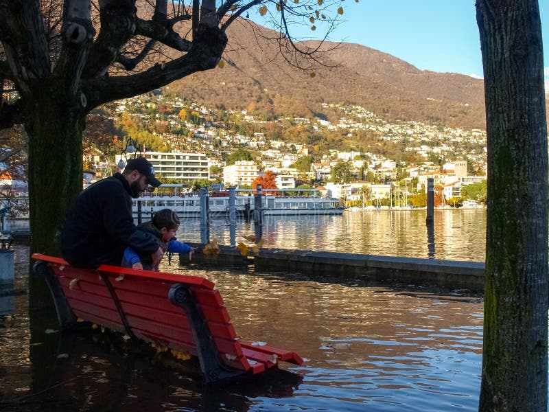 Locarno, Father and son playing throw the leaves in water. stock image Locarno, Father and son playing throw the leaves in water. stock image