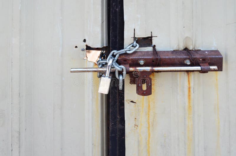 Locked Padlock and Chained on Galvanize Metal Sheet Door Stock Photo