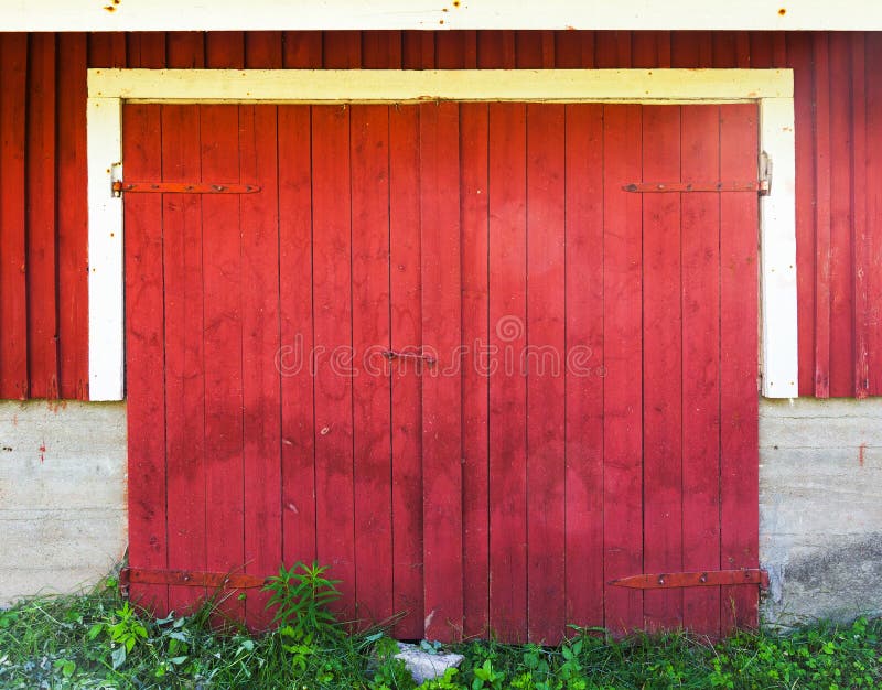 Locked red wooden gate in rural barn wall