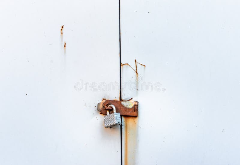 Locked Simple Metal Padlock Hanging on Rusted Hasp on Metal Doors