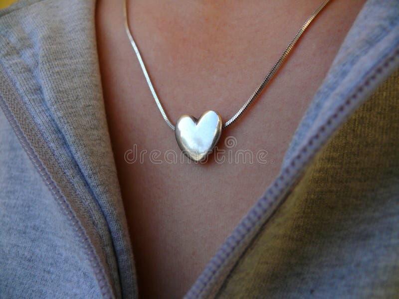 Heart-shaped locket in woman chest. Heart-shaped locket in woman chest