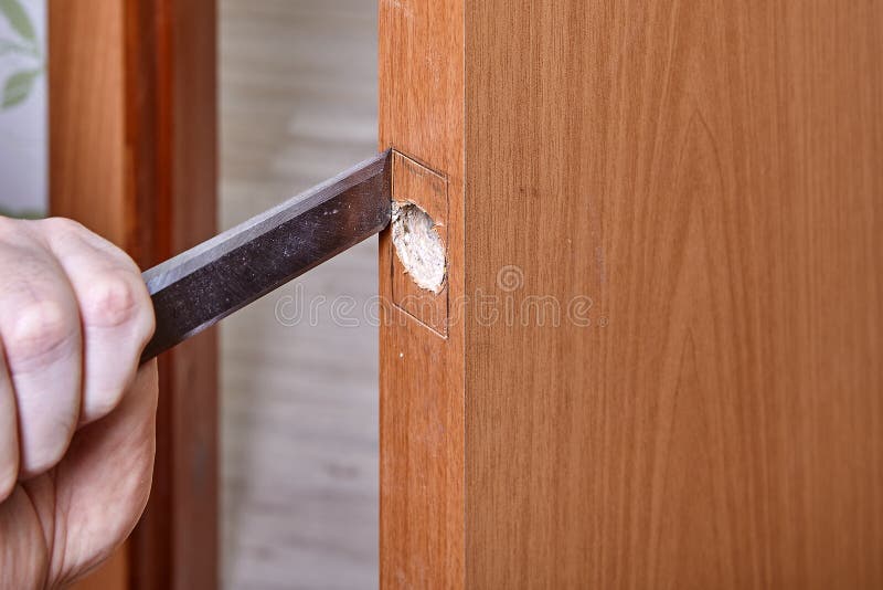 Handyman Chisels Wood Along the Lip for the Plate Latch To Slot into