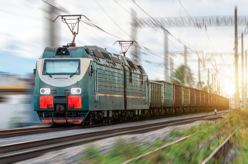 Locomotive electric with a freight train at high speed rides by rail.