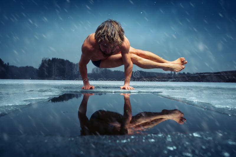 Man doing yoga exercise, parsva bakasana, on the ice of frozen lake at winter snowy day. Man doing yoga exercise, parsva bakasana, on the ice of frozen lake at winter snowy day