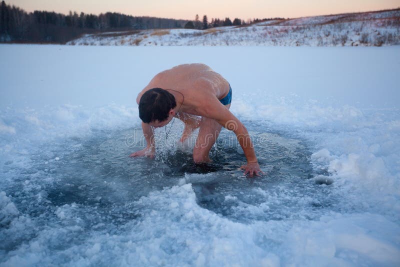 Young man having recreational swim in the ice hole. Young man having recreational swim in the ice hole